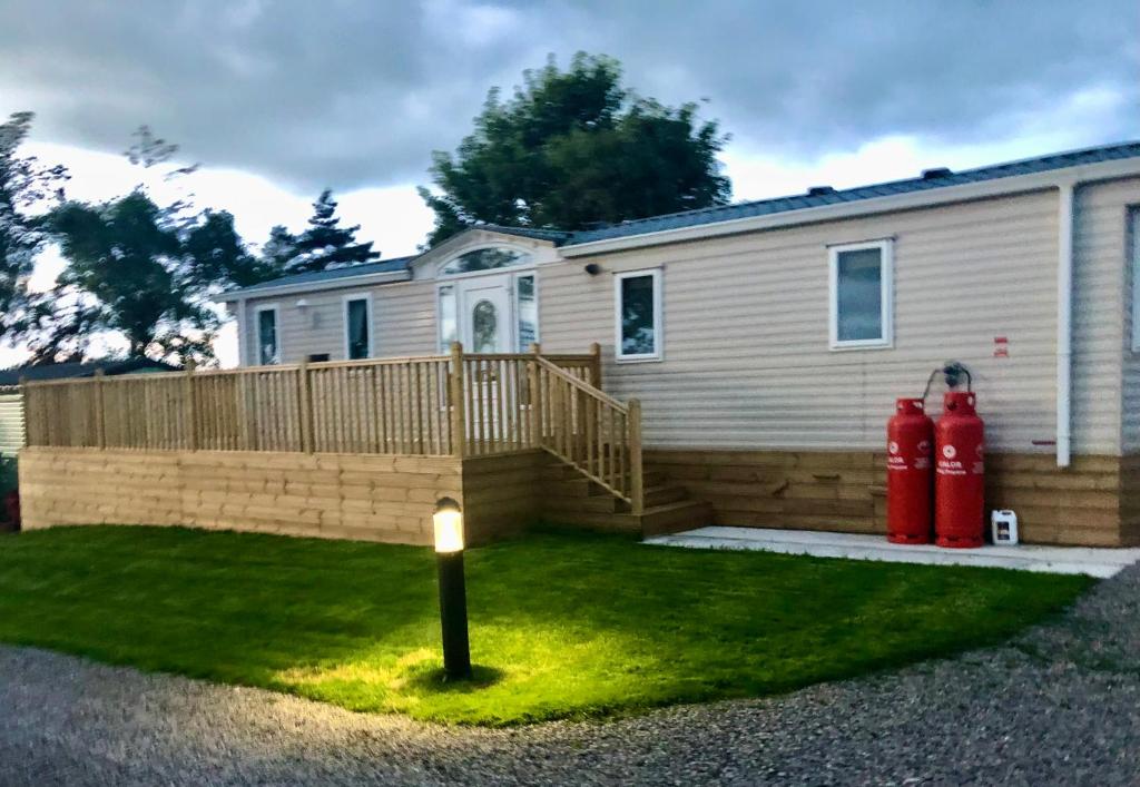a house with two red fire hydrants in the yard at 29 The Beeches in Gilcrux