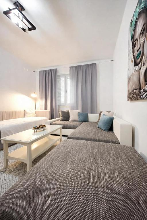 a living room with two beds and a couch at Apartman Cañas Modrá Víla in Rimavská Sobota