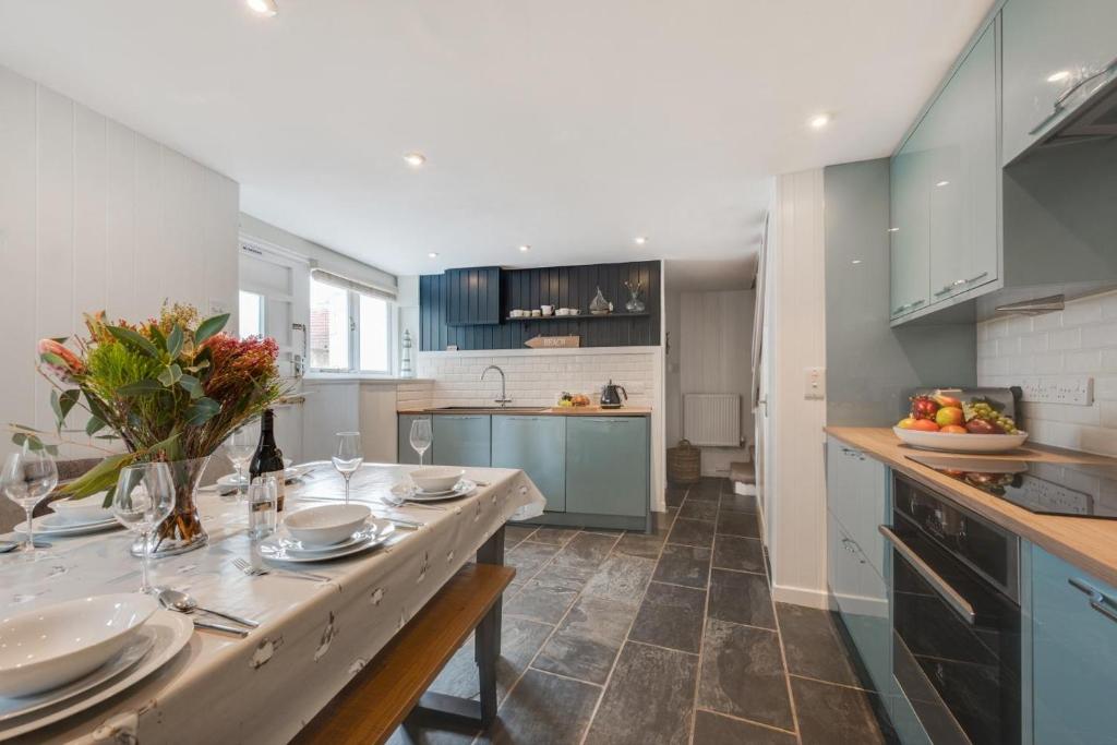 a kitchen with a table with plates and flowers on it at 3 Bed in St. Ives oc-marhou in St Ives