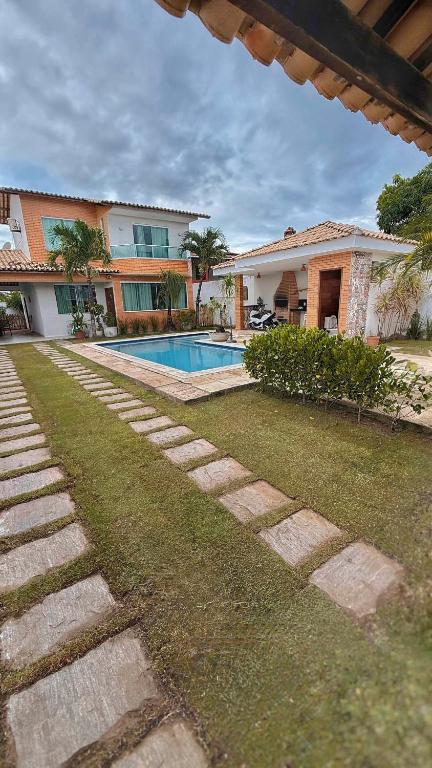 a yard with a house and a swimming pool at Pousada Casa de Praia in Marechal Deodoro