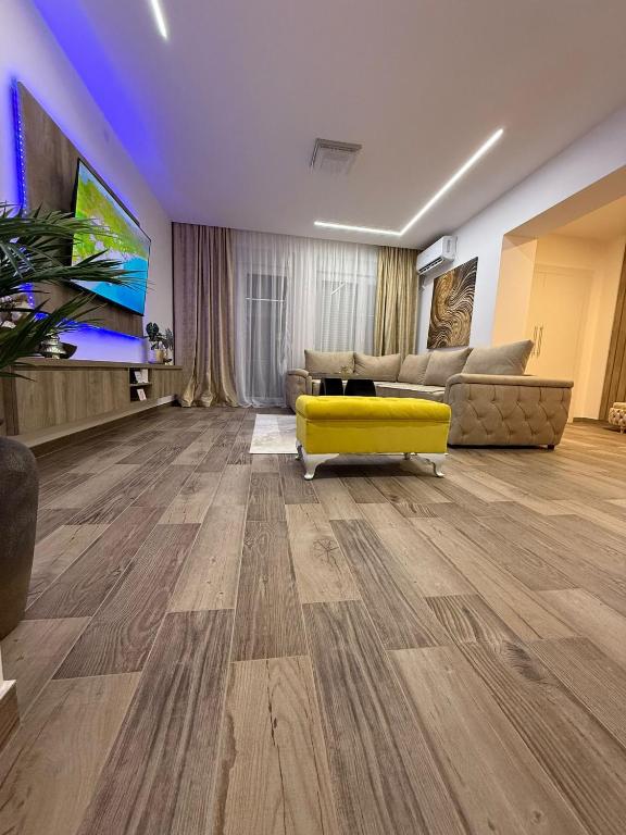 a living room with a yellow couch and a tv at Apartman 28 in Arandelovac