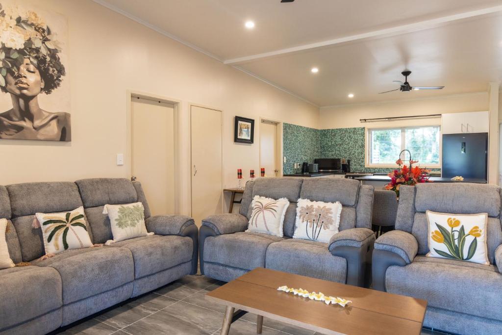 a living room with two couches and a table at Aitutaki Holiday Villa in Arutanga