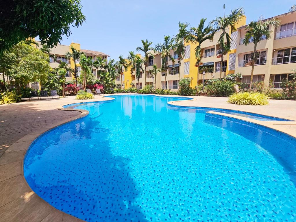 a large blue swimming pool in a resort at Charvi Reemz Anjuna in Anjuna