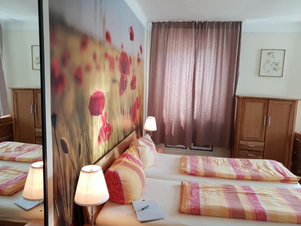 two beds in a hotel room with two lamps at Südhotel in Paderborn