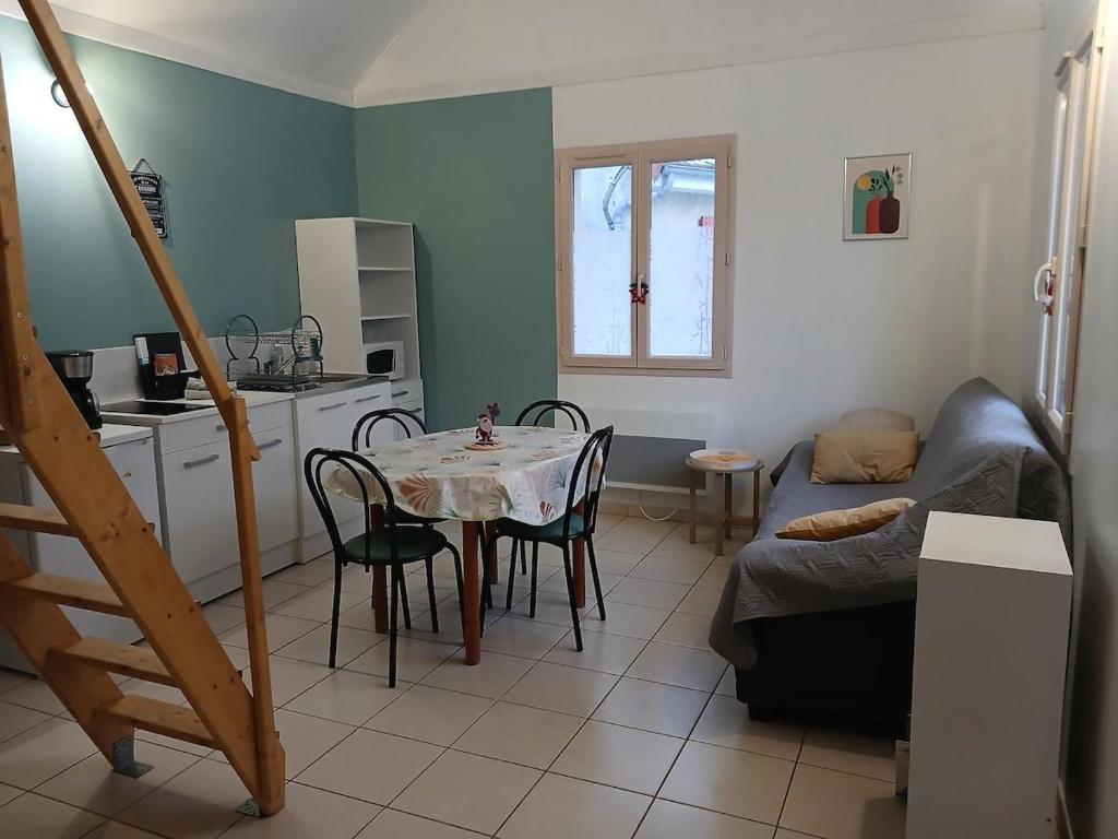 a kitchen and dining room with a table and a couch at Chez Wan'Elle in Thorigné-sur-Dué