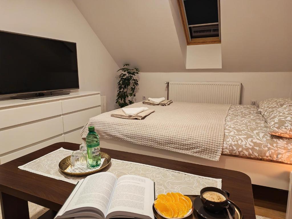 a bedroom with a bed and a table with two books at Csergeteg Családi szállás in Ciceu