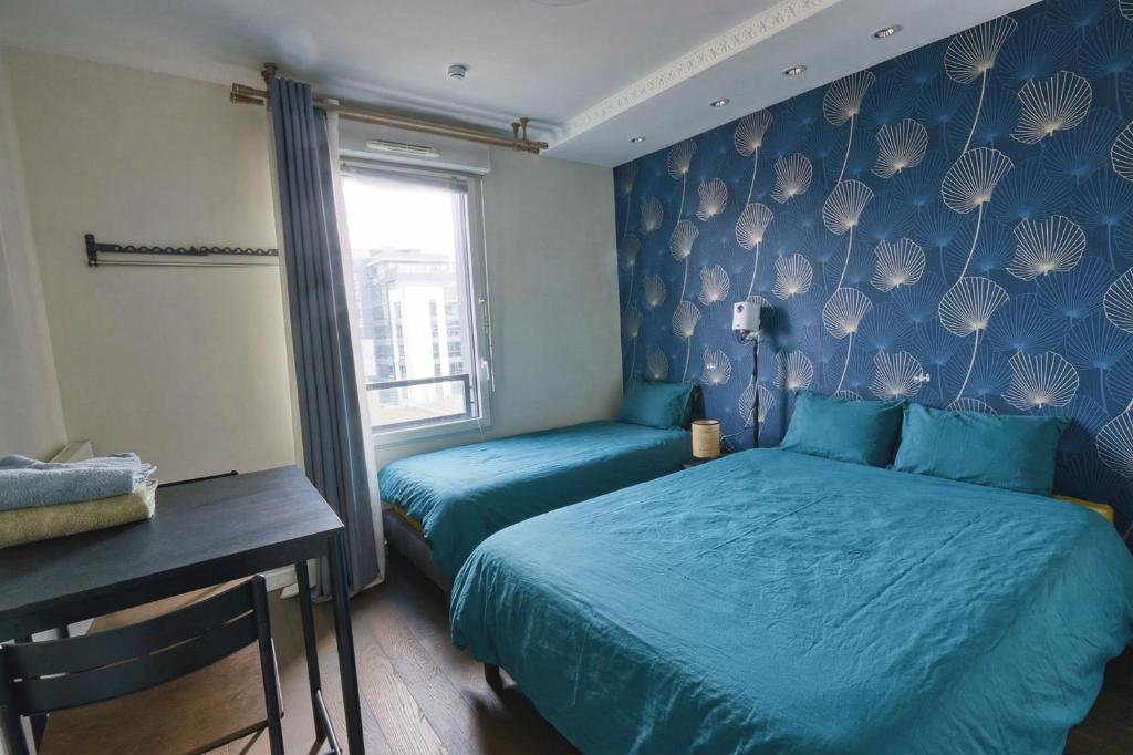 a bedroom with two beds and a desk and a window at Private Room in Coliving - Paris 10min - by Cosynousvoici in Asnières-sur-Seine