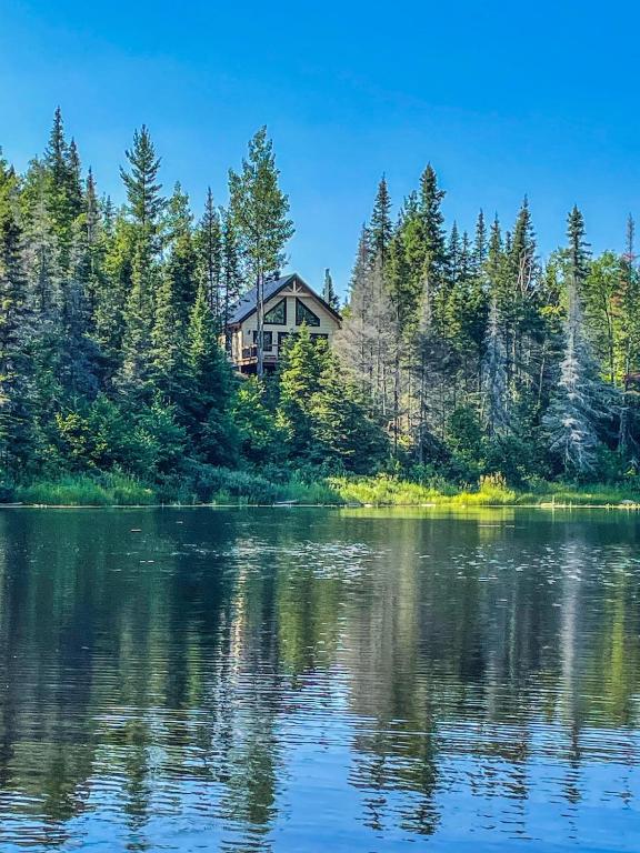 a house on the shore of a lake at Chalet cozy en bord de lac in Saguenay