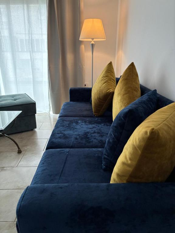 a blue couch with pillows in a living room at Bejart Apartment 8 in Tirana