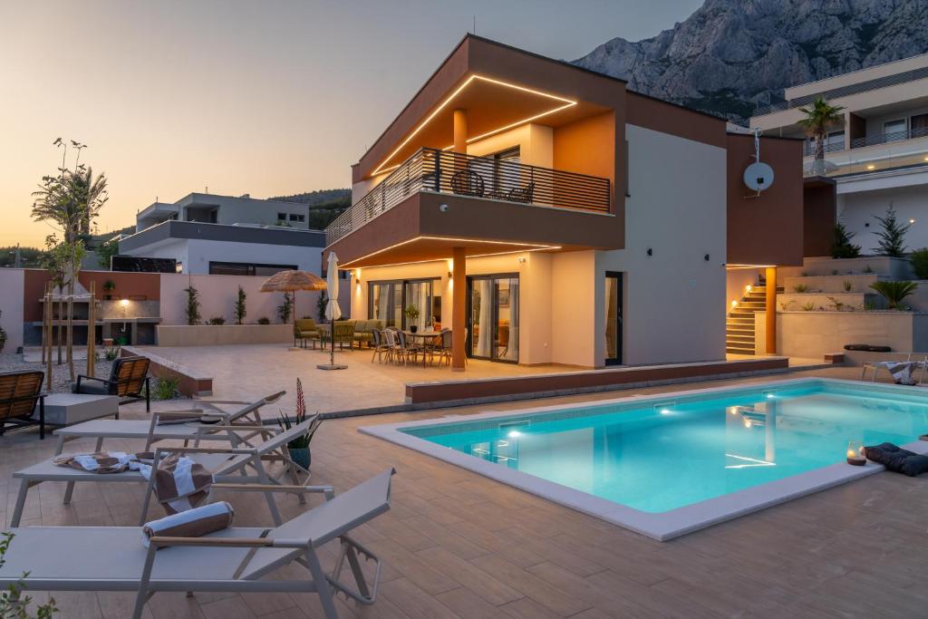a villa with a swimming pool in front of a house at Villa Marko Forever in Makarska