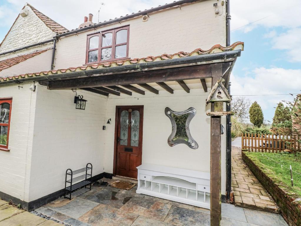a white house with a wooden door at Woodpit Cottage in Nottingham