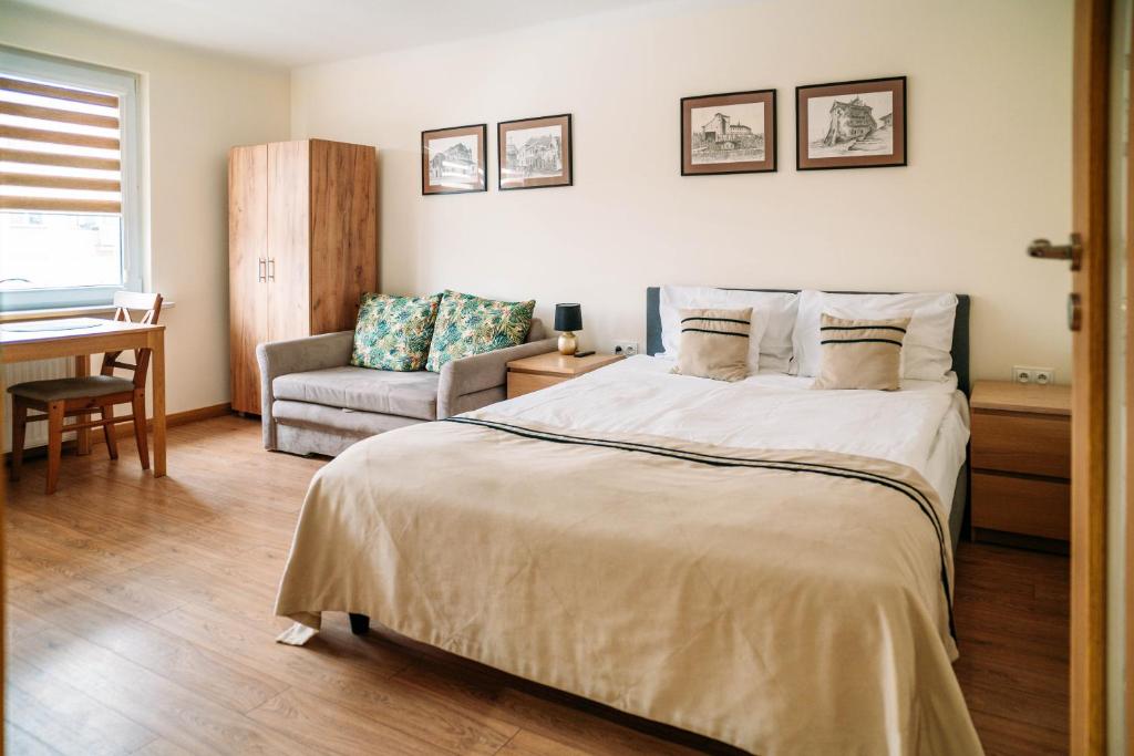 a bedroom with a large bed and a chair at Apartament Sandomierski in Sandomierz