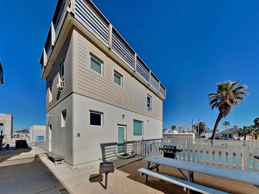 a white building with a bench in front of it at 7 Heaven in Port Aransas