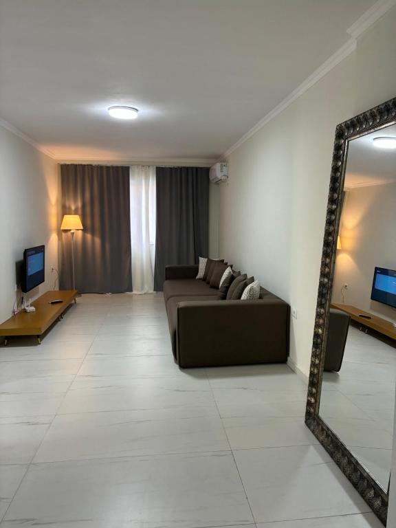 a living room with a couch and a mirror at Bejart Apartment 9 in Tirana