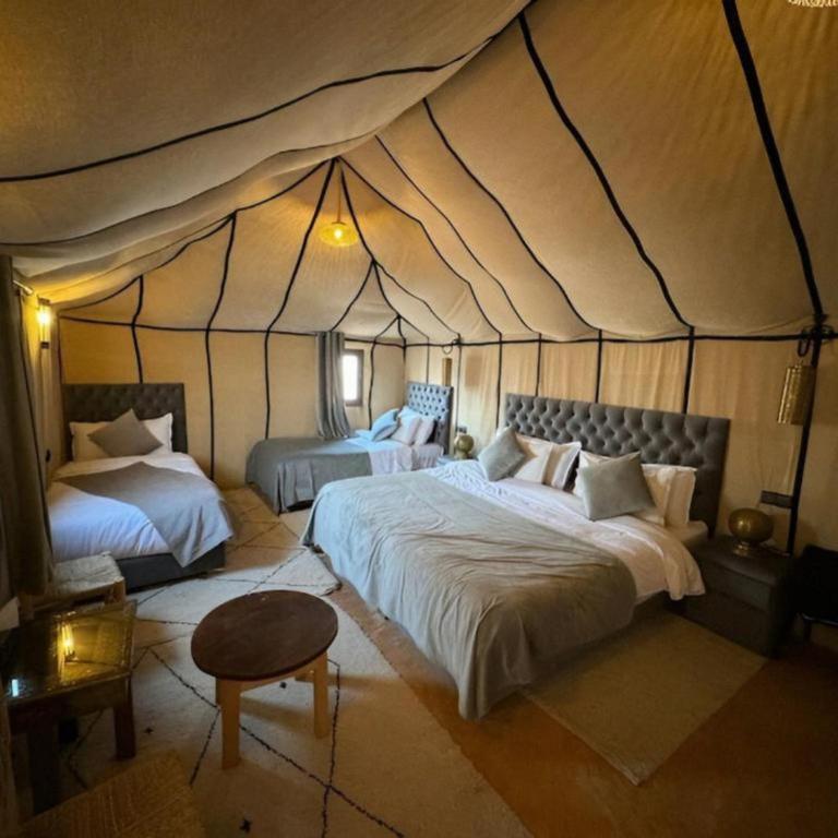 a bedroom with two beds in a tent at Dream Land Camp in Merzouga