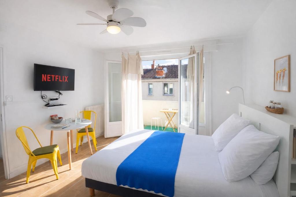 a bedroom with a bed and a table and chairs at Le Kuku Beach - Appartement de charme à Digoin in Digoin