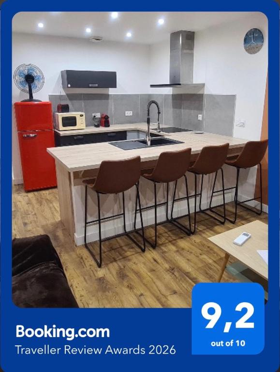 a kitchen with a sink and a counter with stools at Appartement centre-ville, Valras-Plage, chez Géraud et Séverine in Valras-Plage