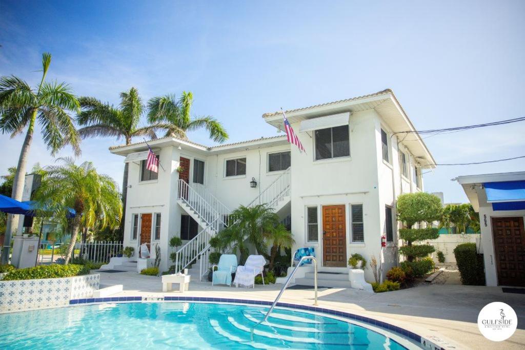 a house with a swimming pool in front of a house at Gulfside Resort Unit 4 in St. Pete Beach