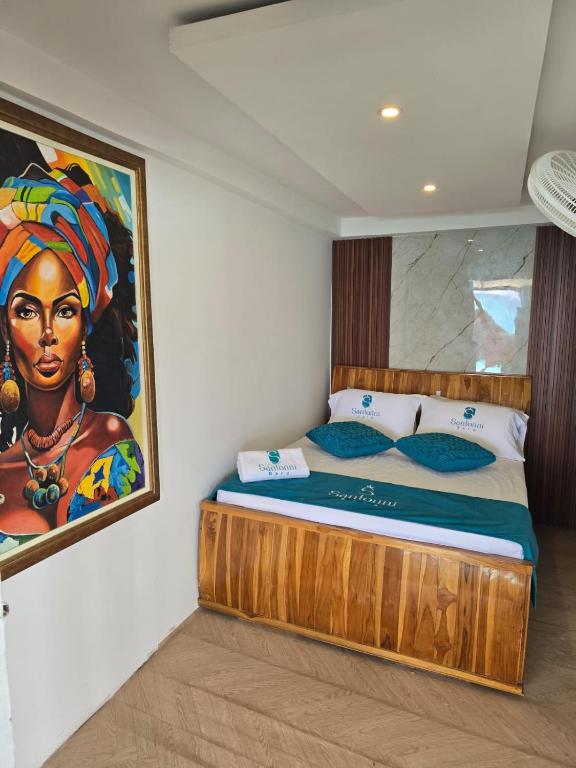 a bed in a room with a painting on the wall at Santorini Barú in Playa Blanca