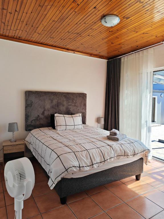 a bedroom with a large bed with a wooden ceiling at Kubata Diame B&B in Cape Town