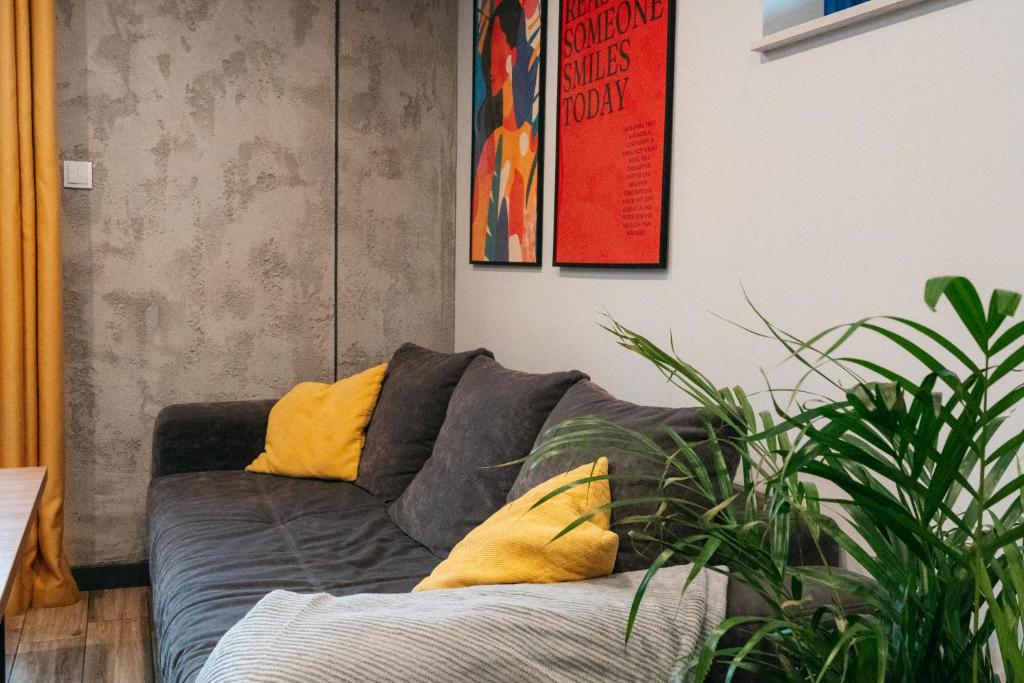 a living room with a couch with yellow pillows at Derylovka - domki, jacuzzi, sauna in Zamość