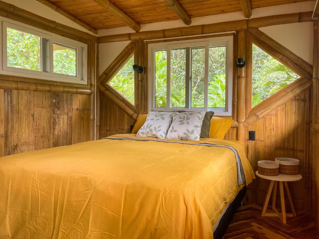 un letto in una stanza di legno con due finestre di Casa Oak a Tzununá