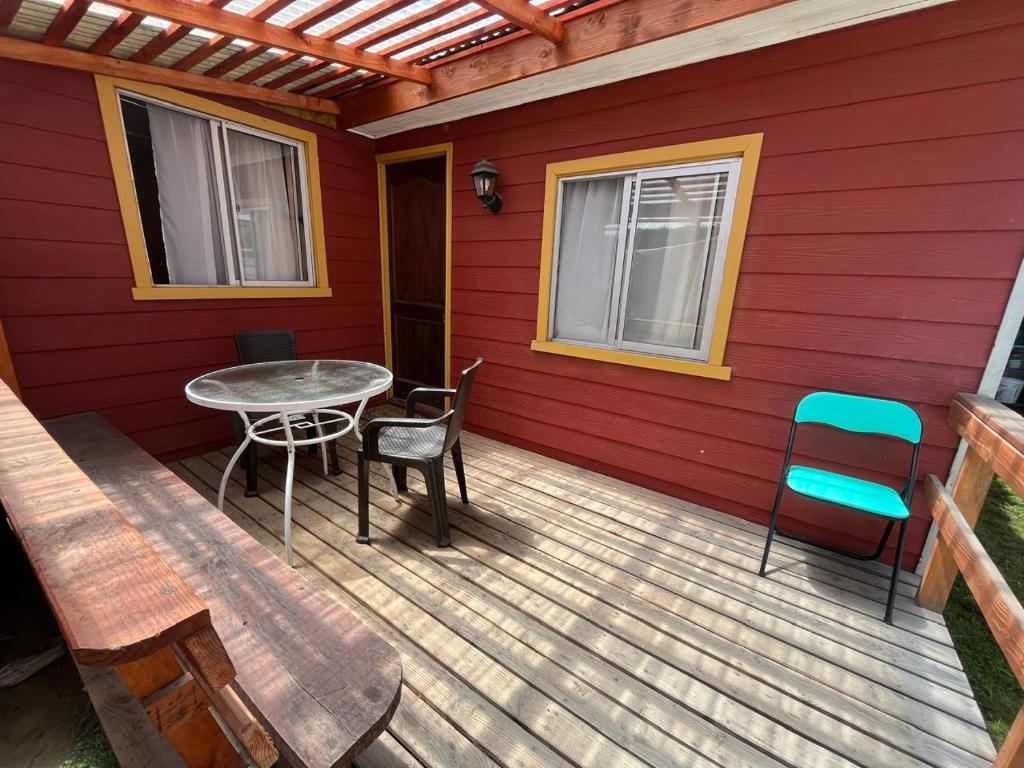 a wooden deck with a table and chairs on it at Cabaña Terraza Choshuenco in Panguipulli