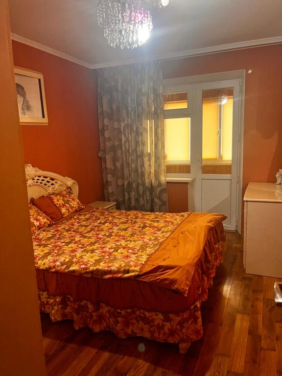 a bedroom with a bed and a chandelier at City Relax in Bălţi
