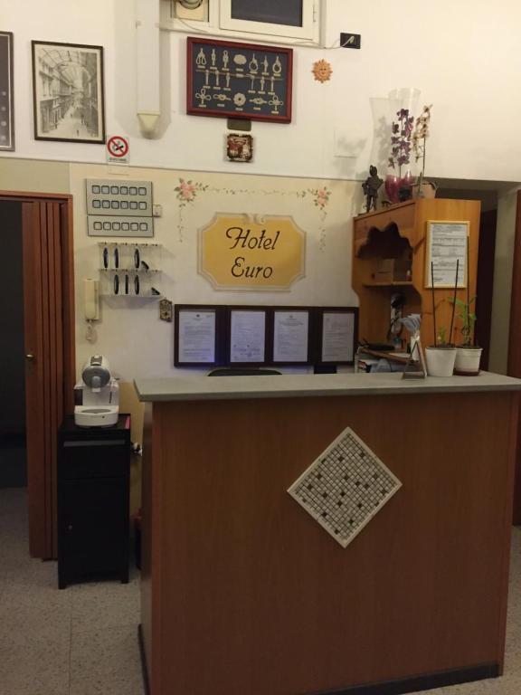 a reception desk in a office with a sign on the wall at Hotel Euro in Genoa