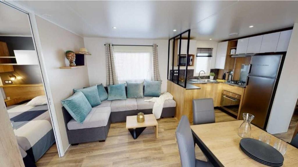 a large living room with a couch and a kitchen at Vacances la Palmyre in Les Mathes