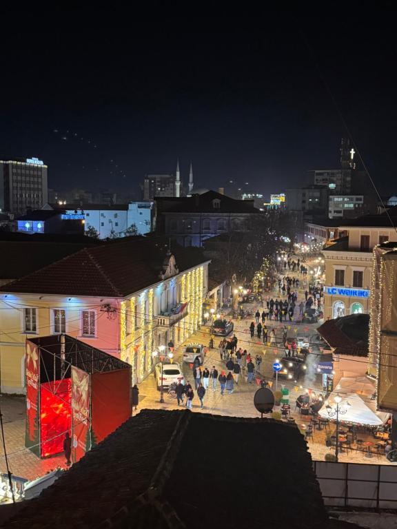a group of people walking down a street at night at Pedestrian Street Center Apartment in Shkodër