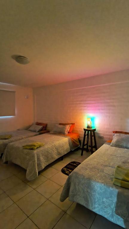 two beds in a room with a pink wall at La Angelica in Juana Koslay 