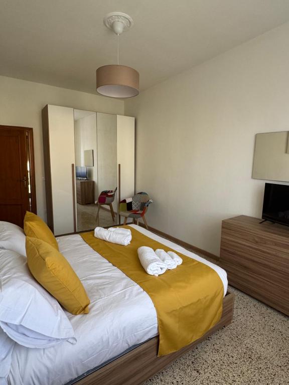 a bedroom with a large bed with two towels on it at Villa Elettra in Pisa