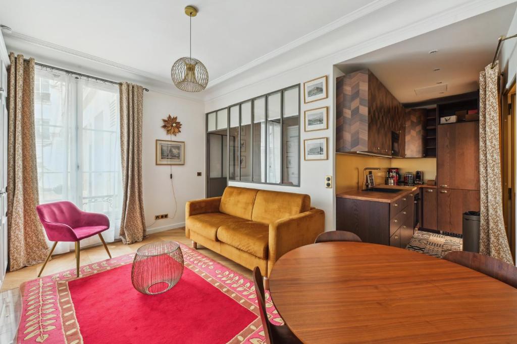 a living room with a table and a couch at La Maison Kléber - Luxury apartments, Eiffel Tower - Champs-Elysées in Paris
