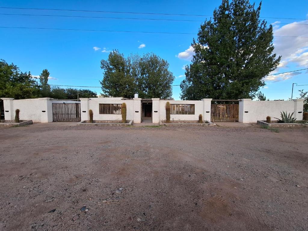 a white building with gates on a dirt road at San Antonio Casa Quinta in Banda Florida