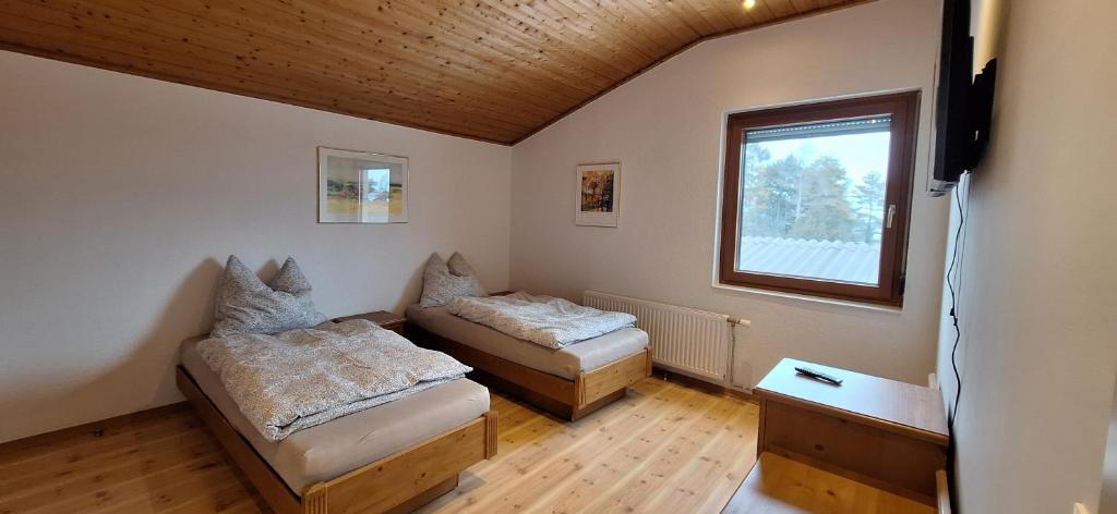 a room with two beds and a window at Lauermann's Gästehaus in Felixdorf