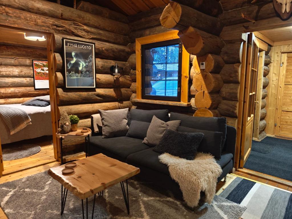 a living room with a couch in a log cabin at Holiday Hopsukka in Luosto