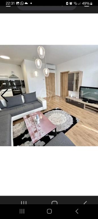 a living room with a couch and a tv at Apartment brand new in Seredʼ