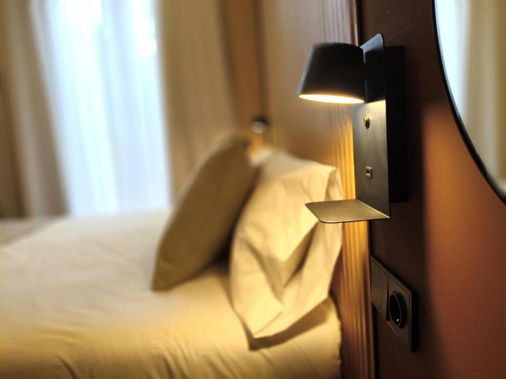 a hotel room with a bed with pillows and a lamp at Marina Boutique in Valencia