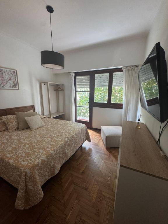 a bedroom with a bed and a flat screen tv at Departamento luminoso con balcón in La Plata