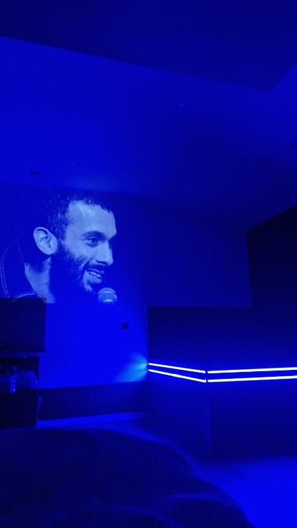 a man standing in a dark room with a microphone at Chez sousouzen in Dunkerque