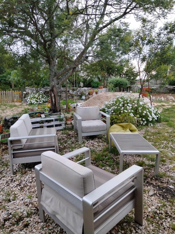 a group of chairs and tables and a tree at Casinha de Chanca in Chanca