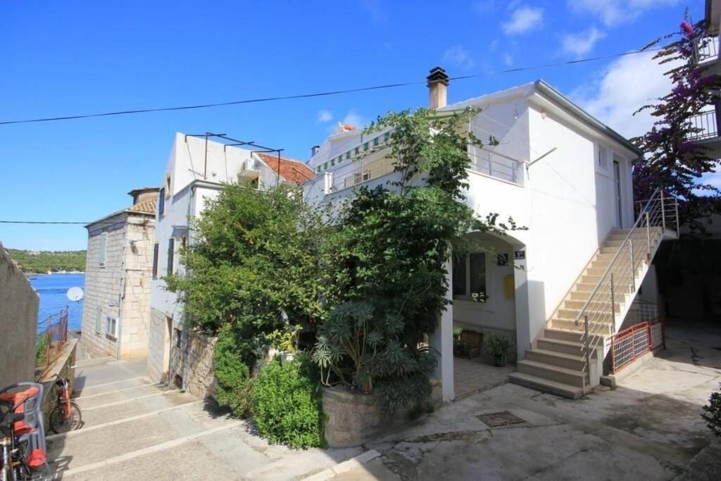 a white house with stairs and a tree at Apartments Zoki in Vis