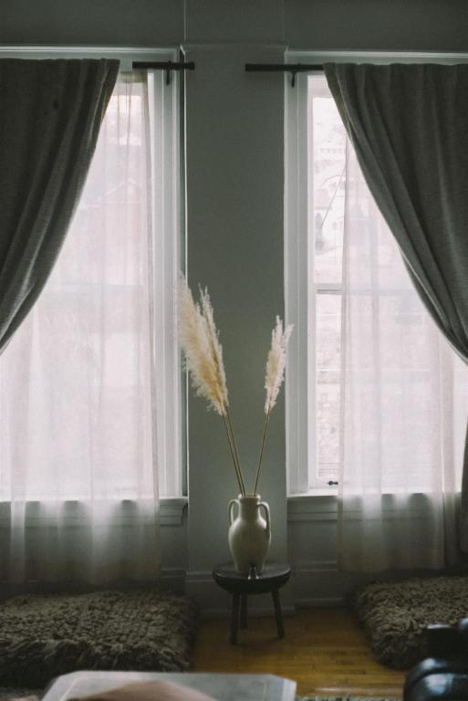 a vase with feathers in a room with windows at Object Hotel 2BR Room 2A in Bisbee