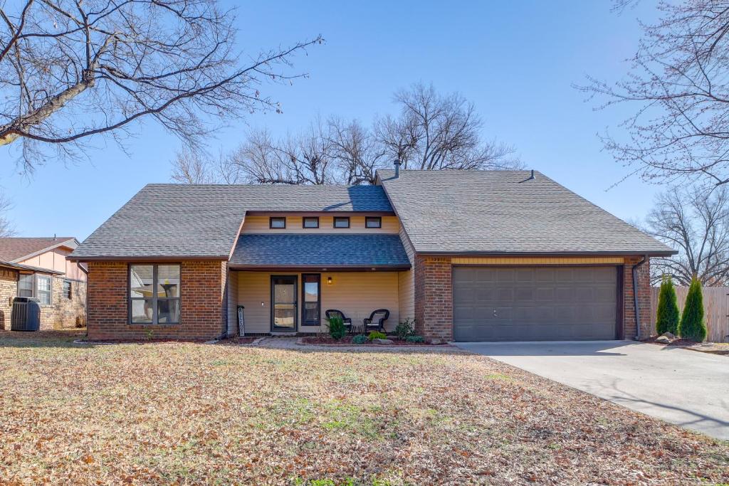 a brown brick house with a garage at Groups Welcome, Central Location! Tulsa Gem + Yard in Tulsa
