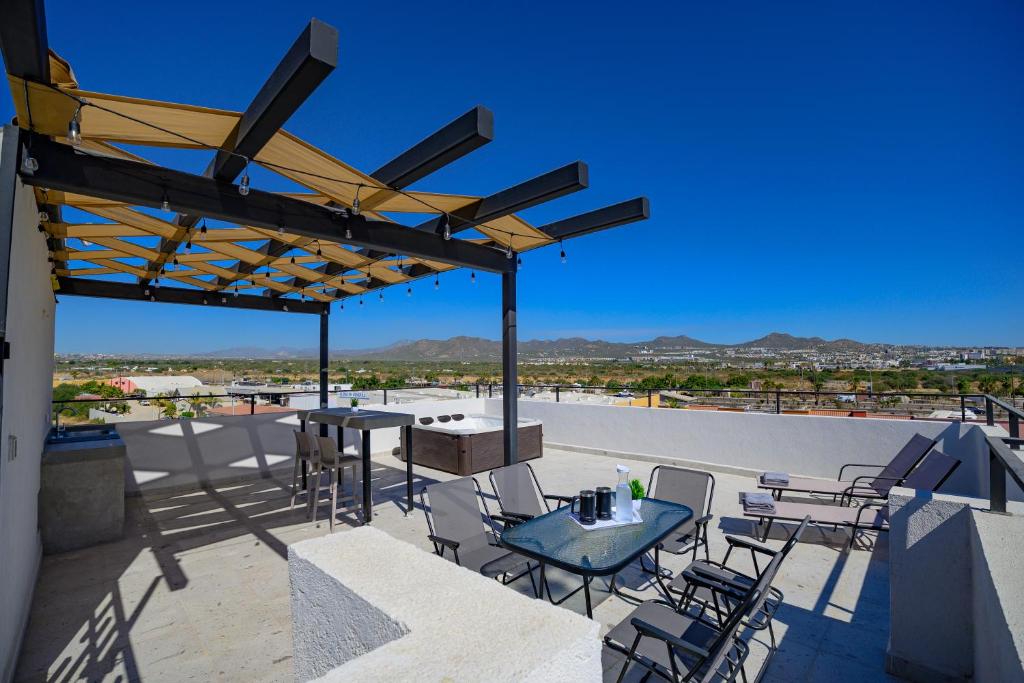 a patio with tables and chairs on a roof at Departamento La Paloma in Cabo San Lucas