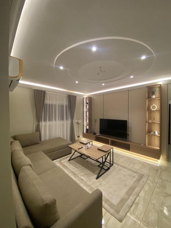 a living room with a couch and a table at Izdihar Dalis Suites in Quai