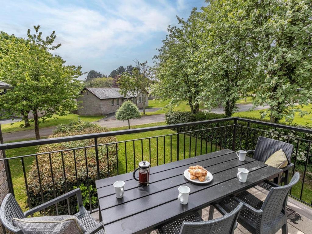 a table with a plate of food on a balcony at 2 Bed in Saltash oc-87708 in St. Mellion