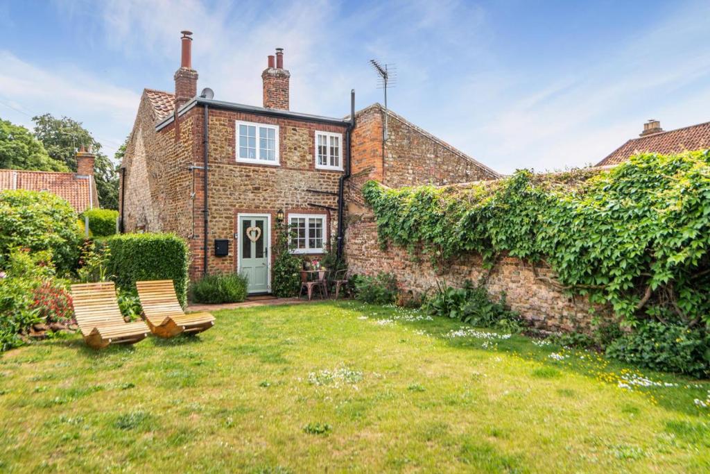 a brick house with two benches in the yard at 2 Bed in Heacham oc-2013 in Heacham