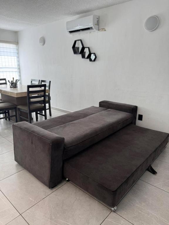a large brown bed in a room with a table at Casa Toreo in Mazatlán